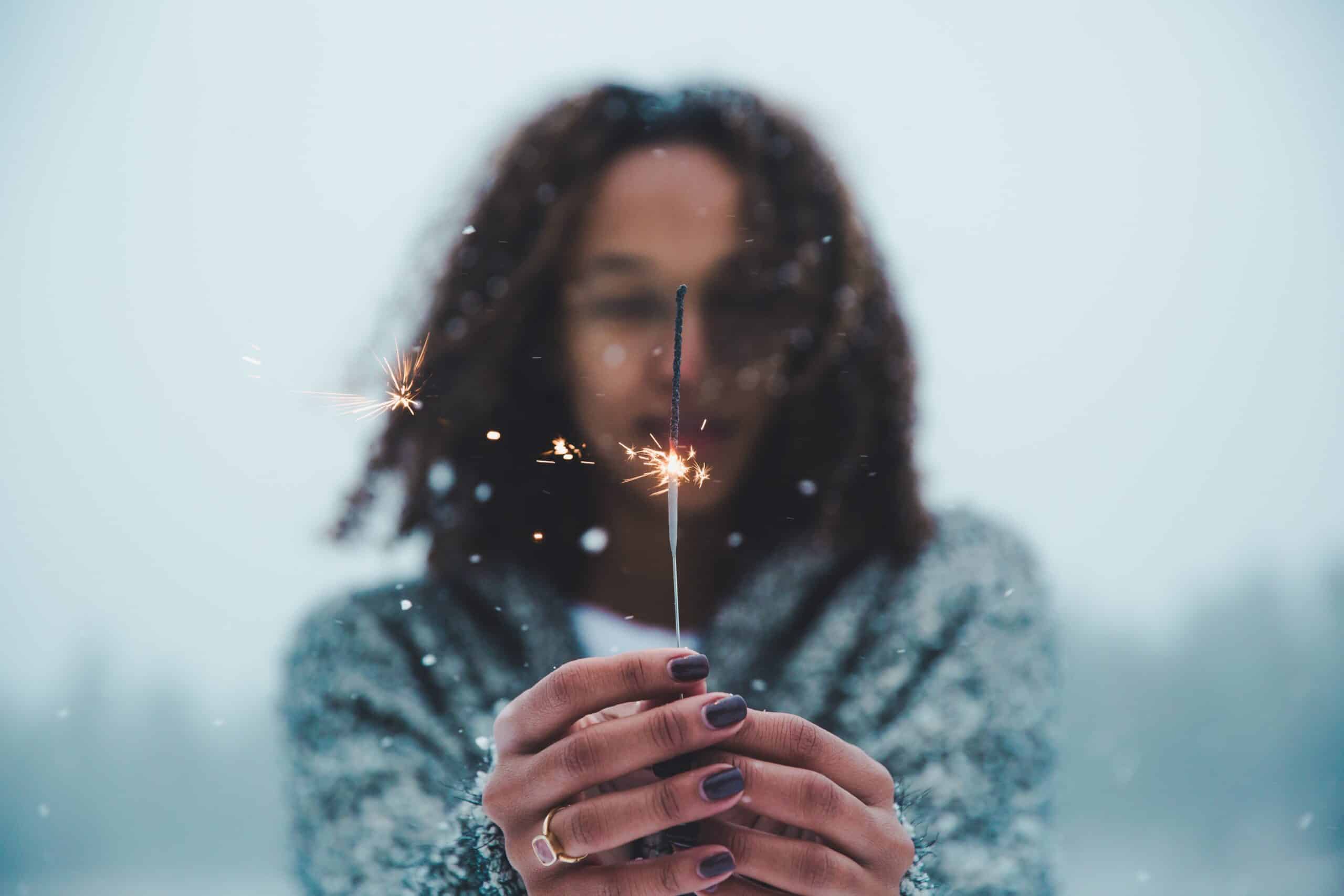 selective focus photography of person holding lighted sparkler