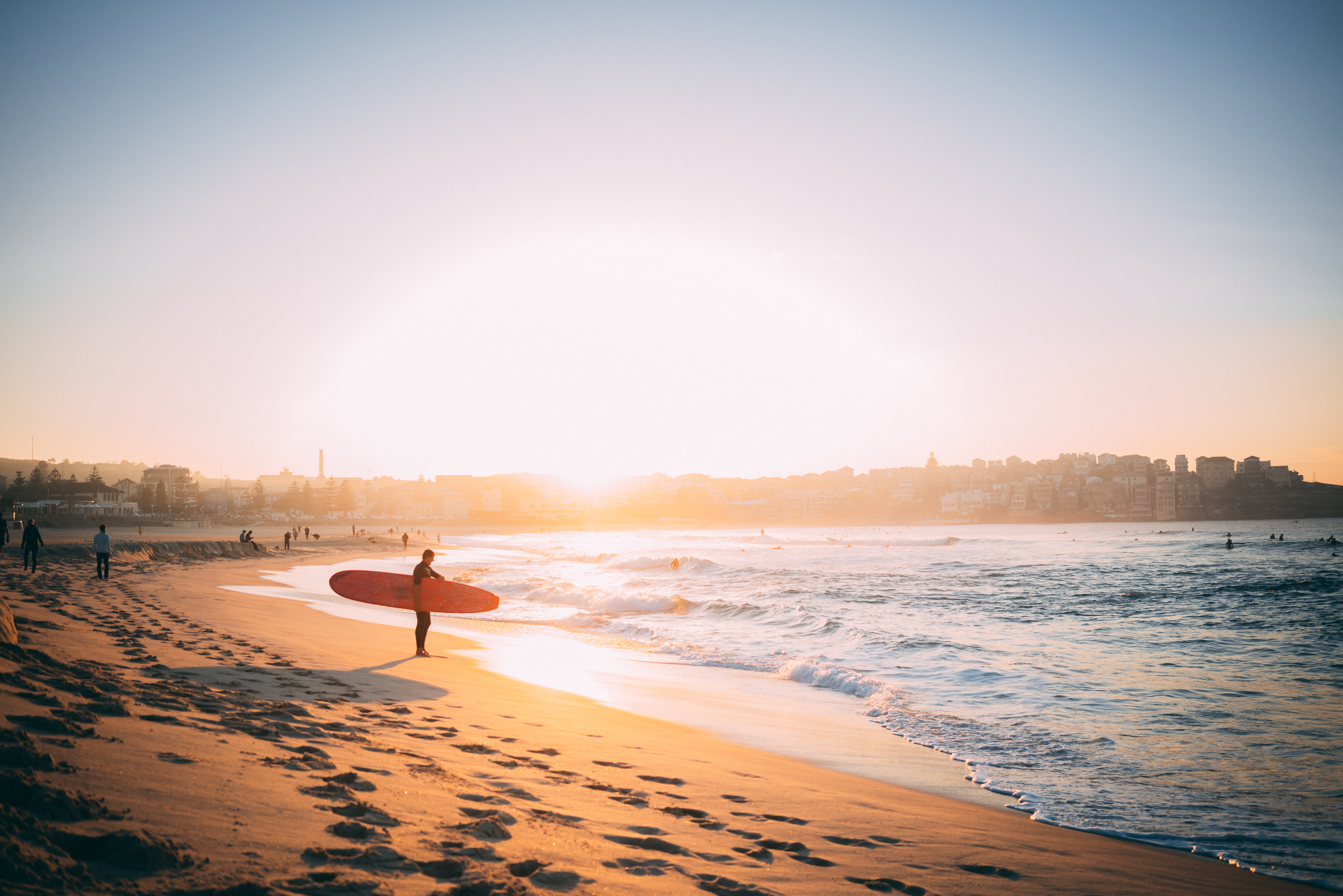 person carrying surfboard at the beach