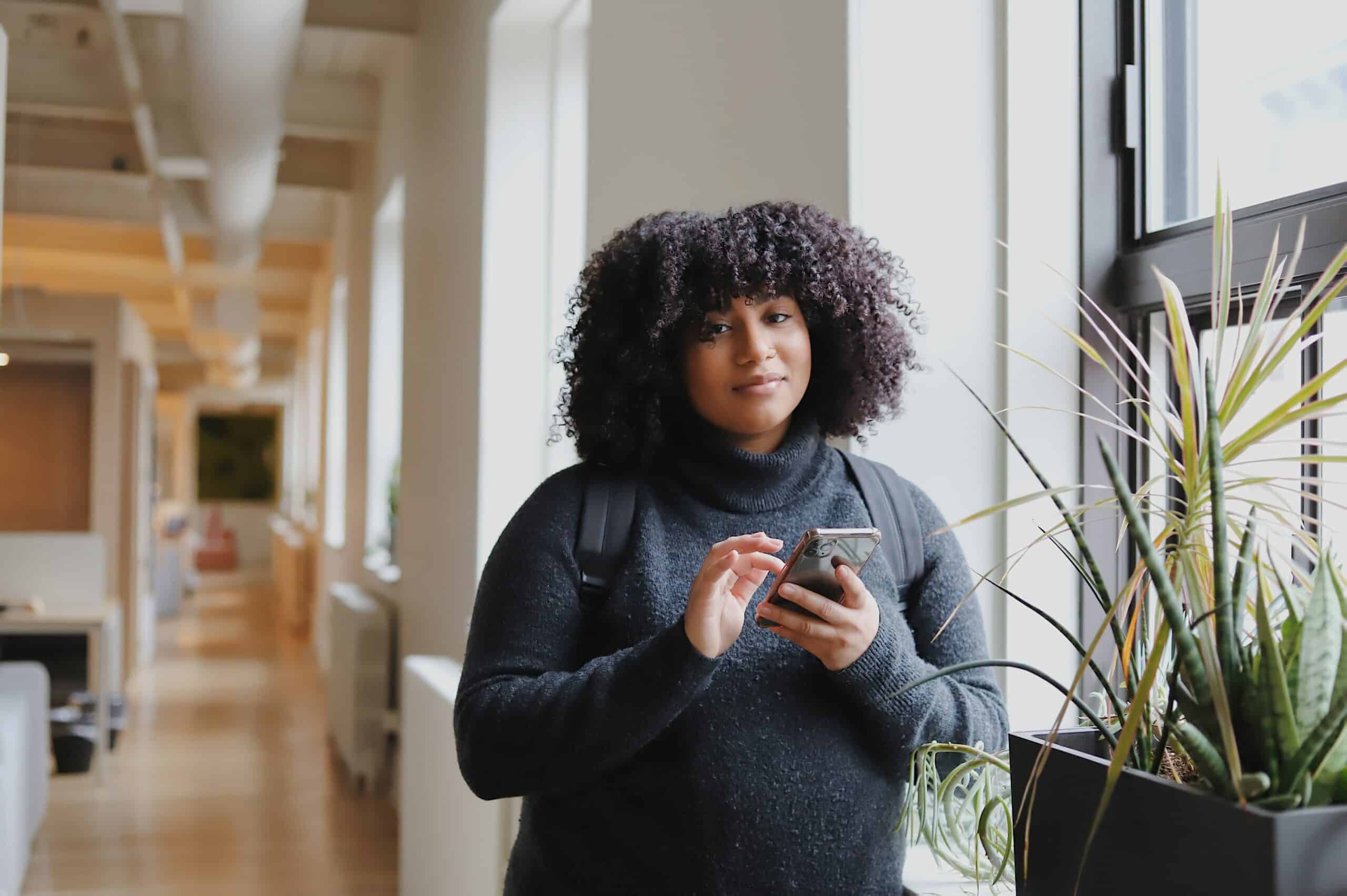 woman in black long sleeve shirt using smartphone