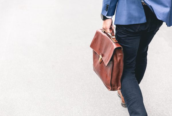 person walking holding brown leather bag