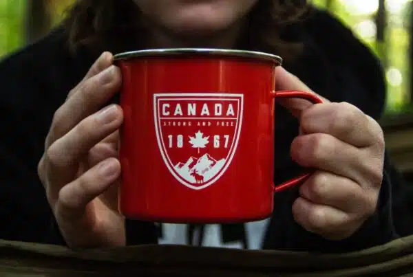 person holding red metal mug
