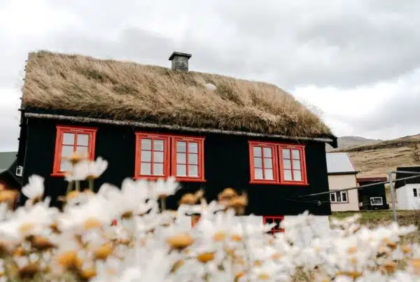 brown and white house near brown mountain under white clouds during daytime