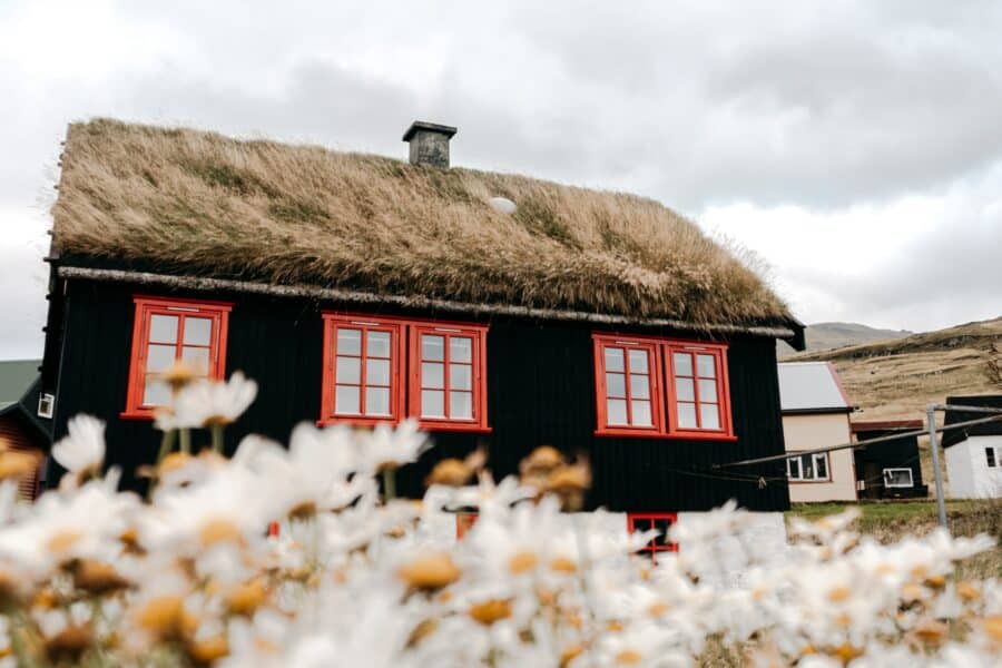 brown and white house near brown mountain under white clouds during daytime